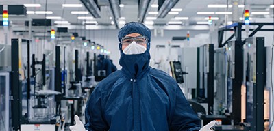 A Wolfspeed Employee in a cleanroom suit